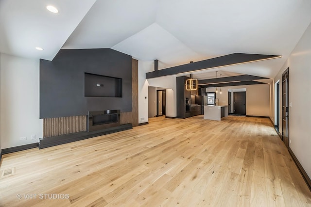 unfurnished living room featuring vaulted ceiling and light wood-type flooring