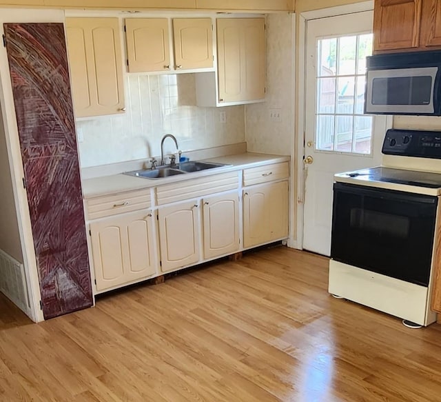 kitchen featuring decorative backsplash, white range, light hardwood / wood-style flooring, and sink