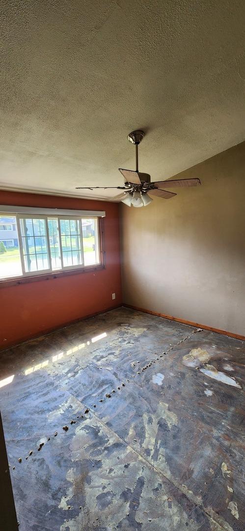 spare room featuring ceiling fan and a textured ceiling