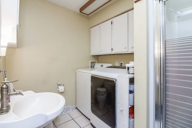 washroom featuring sink, light tile patterned floors, and washer and dryer