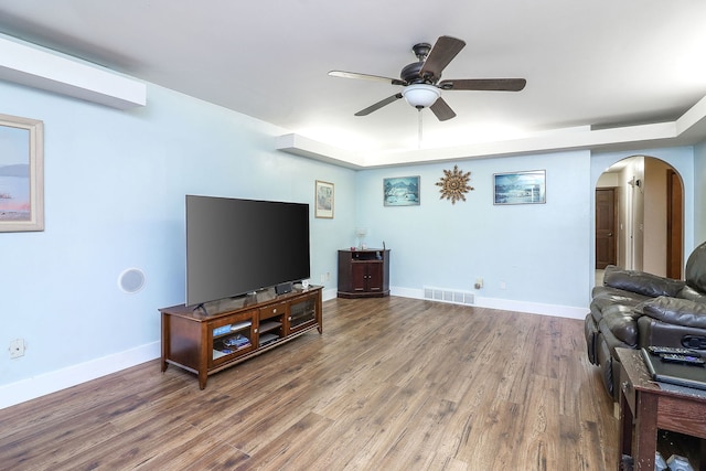 living room featuring ceiling fan and dark hardwood / wood-style floors