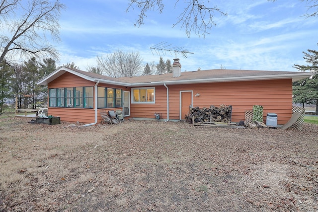 rear view of property featuring a sunroom