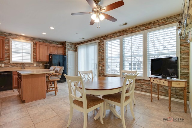 dining space with ceiling fan, light tile patterned floors, and sink