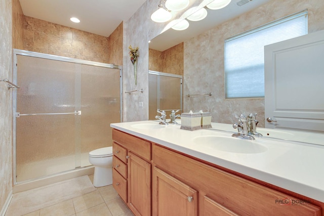 bathroom with tile patterned floors, vanity, toilet, and a shower with door