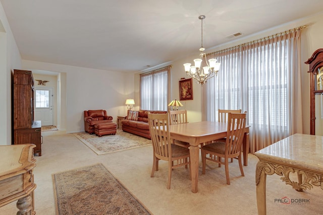 carpeted dining room featuring a chandelier