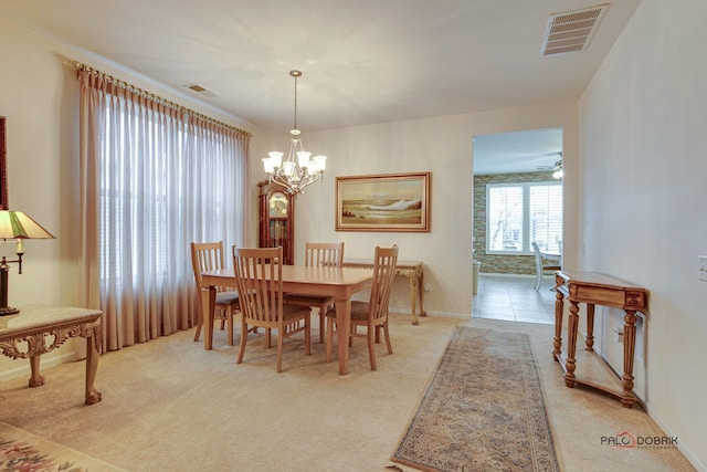 dining room featuring light carpet and a chandelier