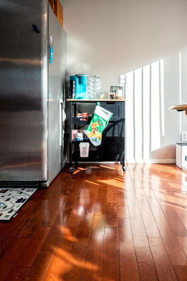 interior details with hardwood / wood-style flooring and stainless steel fridge