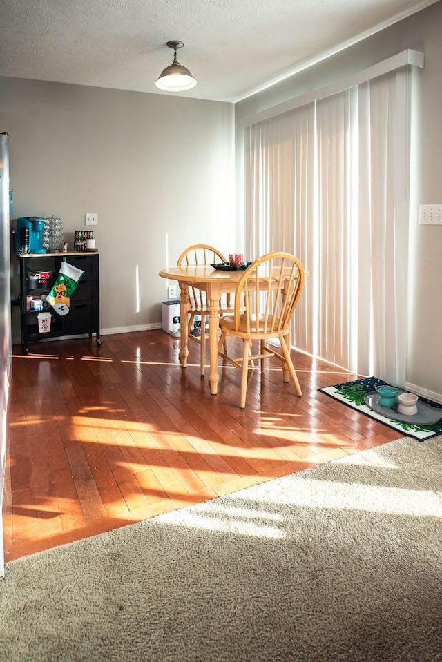 dining space with dark hardwood / wood-style floors and a textured ceiling