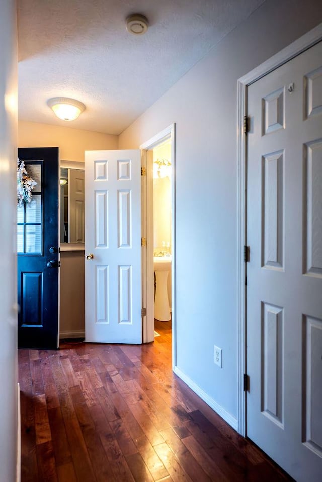 hall featuring dark hardwood / wood-style floors and a textured ceiling