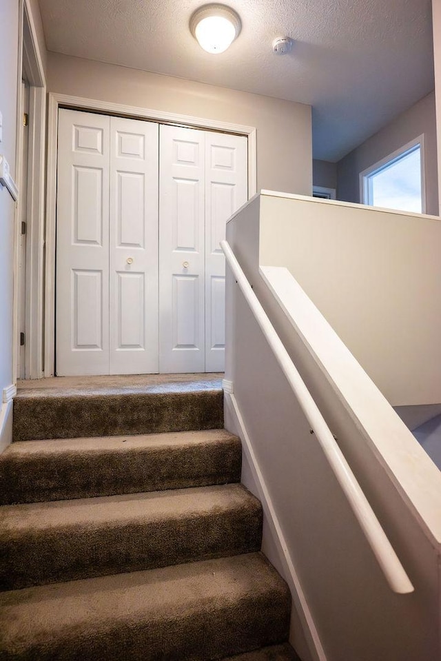 stairs with a textured ceiling