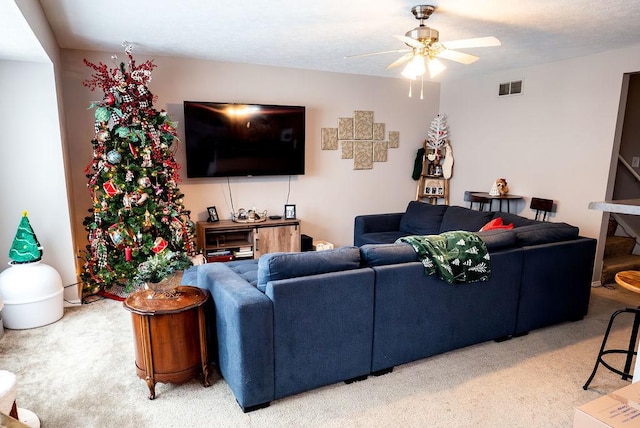 carpeted living room with ceiling fan and a textured ceiling