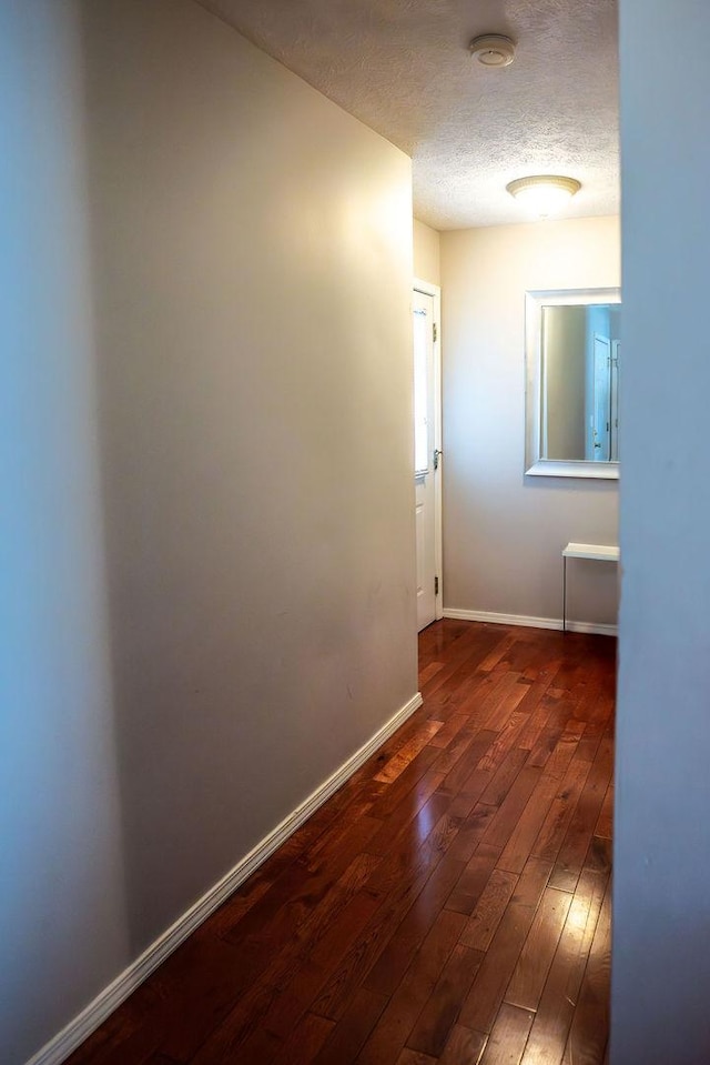 hall with dark hardwood / wood-style floors and a textured ceiling