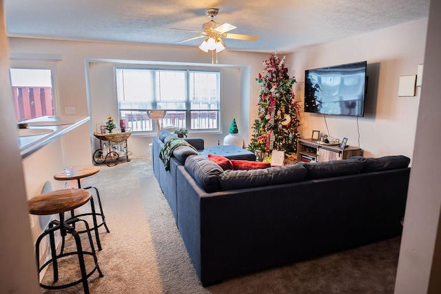 carpeted living room with ceiling fan and a textured ceiling