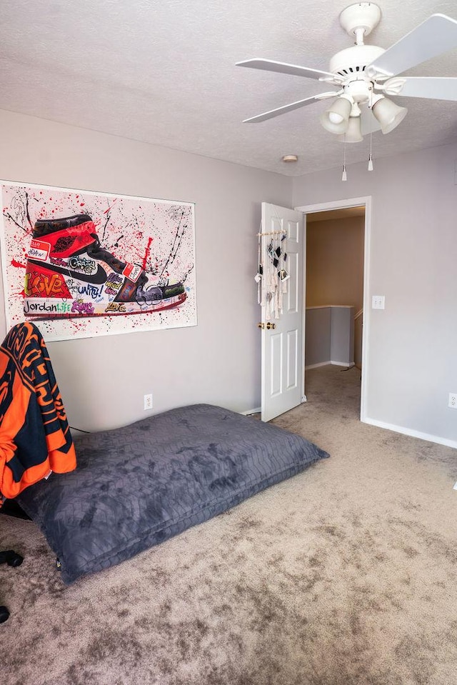 carpeted bedroom featuring a textured ceiling and ceiling fan