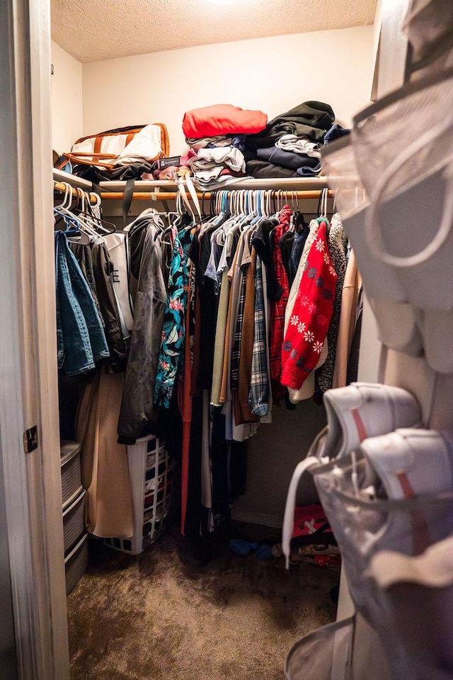 walk in closet featuring dark colored carpet