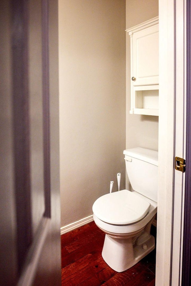 bathroom featuring wood-type flooring and toilet