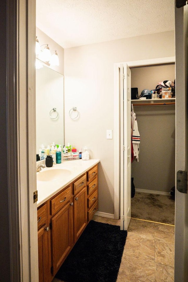 bathroom with a textured ceiling and vanity