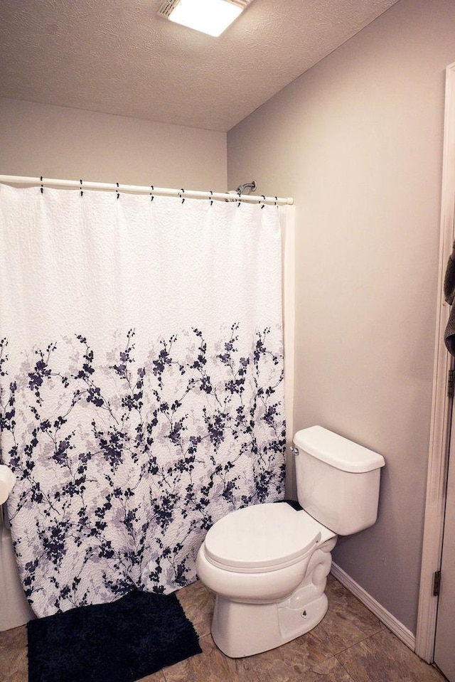 bathroom featuring toilet and a textured ceiling