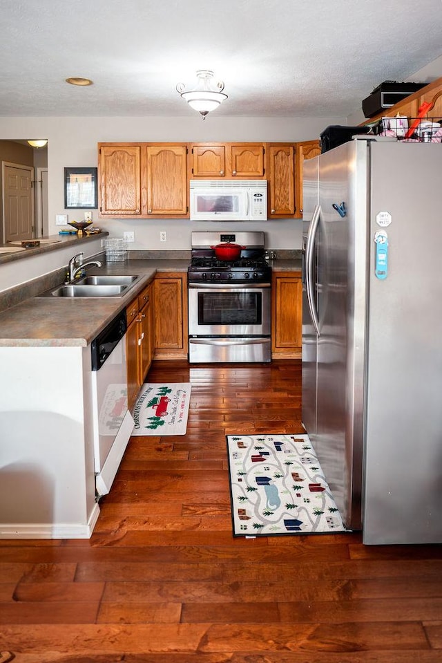 kitchen featuring stainless steel appliances, dark hardwood / wood-style floors, and sink