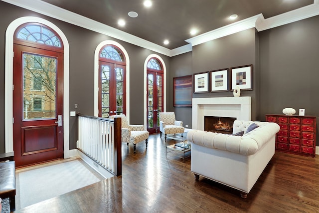 living room with dark hardwood / wood-style floors, a wealth of natural light, and crown molding