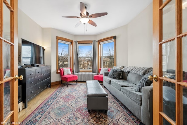 living room with ceiling fan, wood-type flooring, radiator, and french doors