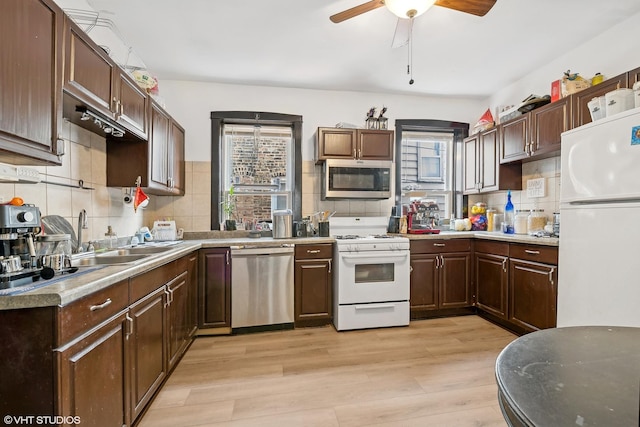 kitchen with ceiling fan, appliances with stainless steel finishes, sink, tasteful backsplash, and light hardwood / wood-style floors