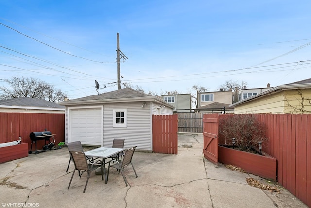 view of patio / terrace featuring a garage, an outbuilding, and grilling area