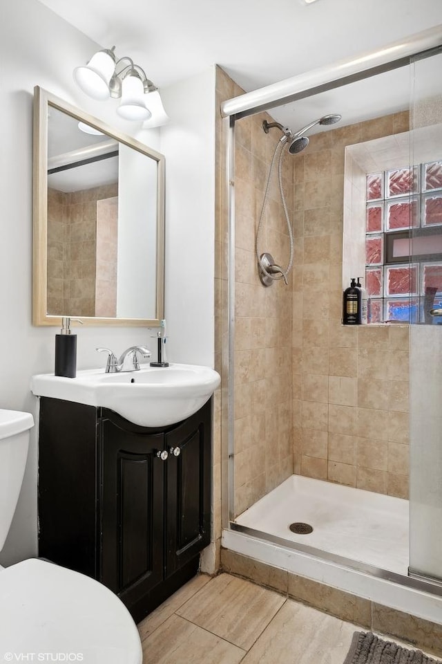 bathroom with toilet, walk in shower, and vanity