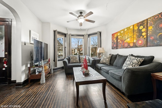 living room featuring ceiling fan and dark wood-type flooring