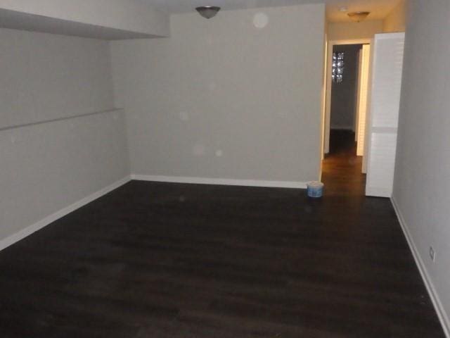 unfurnished room with dark hardwood / wood-style flooring