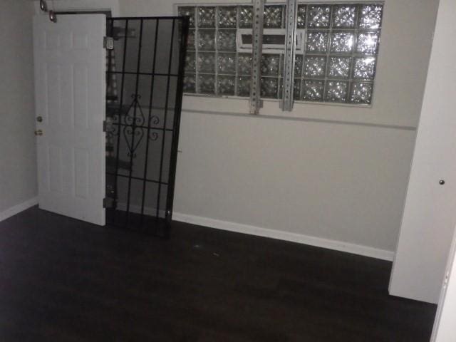 empty room with dark hardwood / wood-style flooring