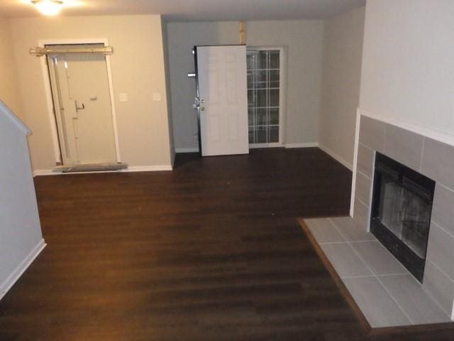 unfurnished living room featuring a fireplace and dark hardwood / wood-style flooring