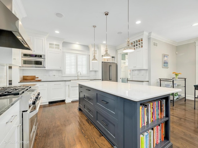 kitchen with a kitchen island, decorative light fixtures, high quality appliances, range hood, and white cabinets