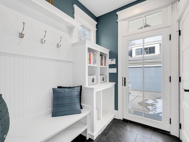 mudroom with dark tile patterned floors