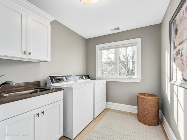 washroom with cabinets, separate washer and dryer, and sink