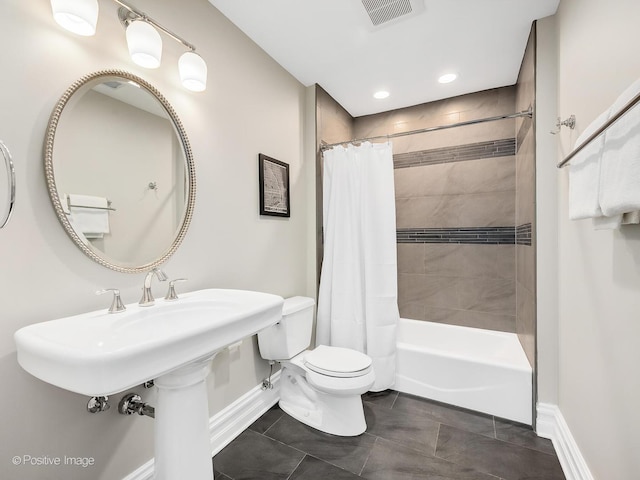 bathroom featuring shower / bathtub combination with curtain, tile patterned floors, and toilet