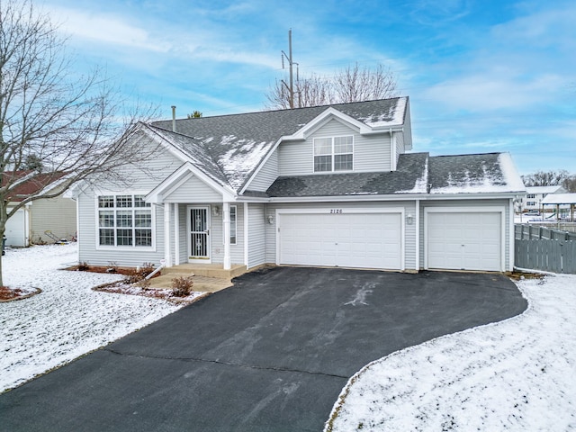 view of front of property with driveway, roof with shingles, and fence