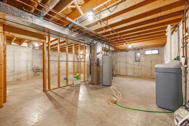 below grade area featuring gas water heater, electric panel, and heating unit