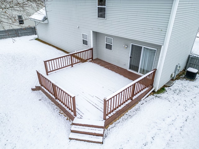 snow covered deck featuring central AC, stairway, and fence