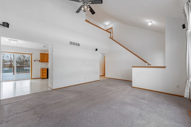 unfurnished living room featuring light colored carpet, visible vents, a ceiling fan, high vaulted ceiling, and baseboards