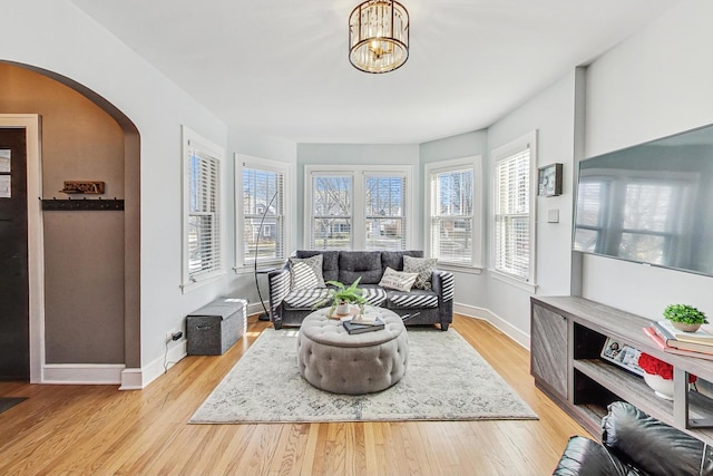 living room featuring a notable chandelier and light wood-type flooring