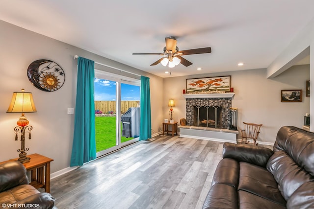 living room with a fireplace, hardwood / wood-style floors, and ceiling fan