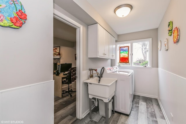 laundry area with hardwood / wood-style floors, cabinets, and washing machine and clothes dryer