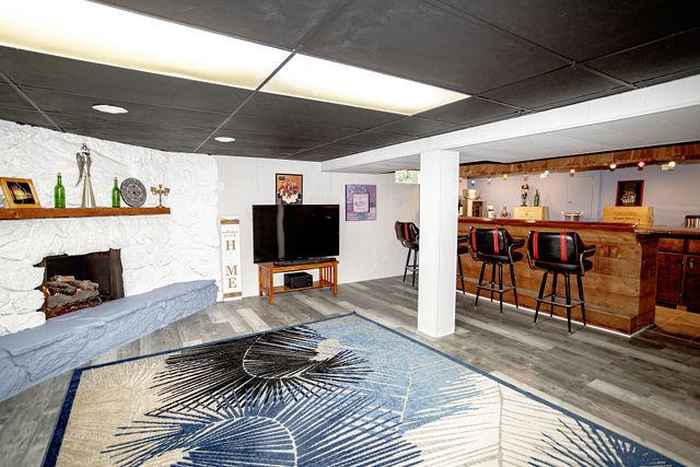 living room featuring hardwood / wood-style floors, a fireplace, and indoor bar