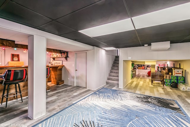 basement featuring hardwood / wood-style flooring and indoor bar