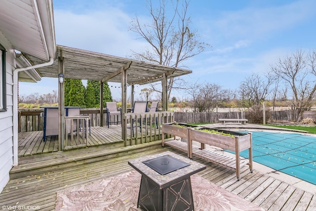 deck featuring a bar, a covered pool, and an outdoor fire pit