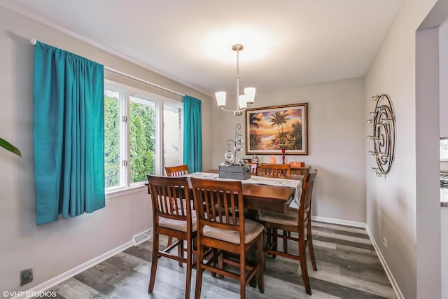 dining area featuring hardwood / wood-style floors and an inviting chandelier