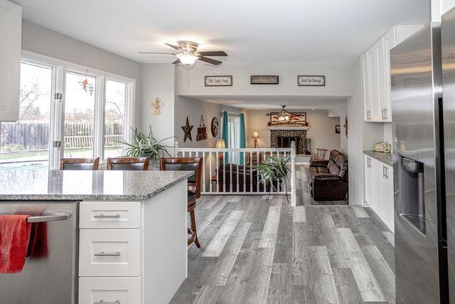 kitchen with light stone countertops, white cabinetry, and stainless steel appliances