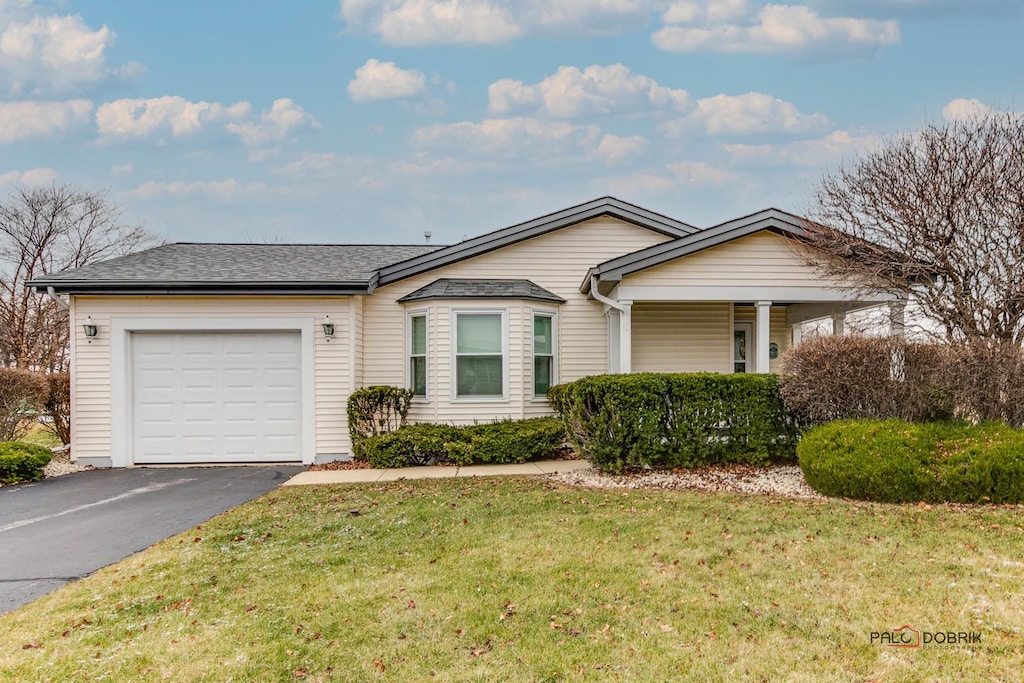 single story home featuring a front yard and a garage