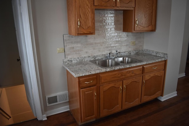 kitchen with tasteful backsplash, dark hardwood / wood-style floors, and sink